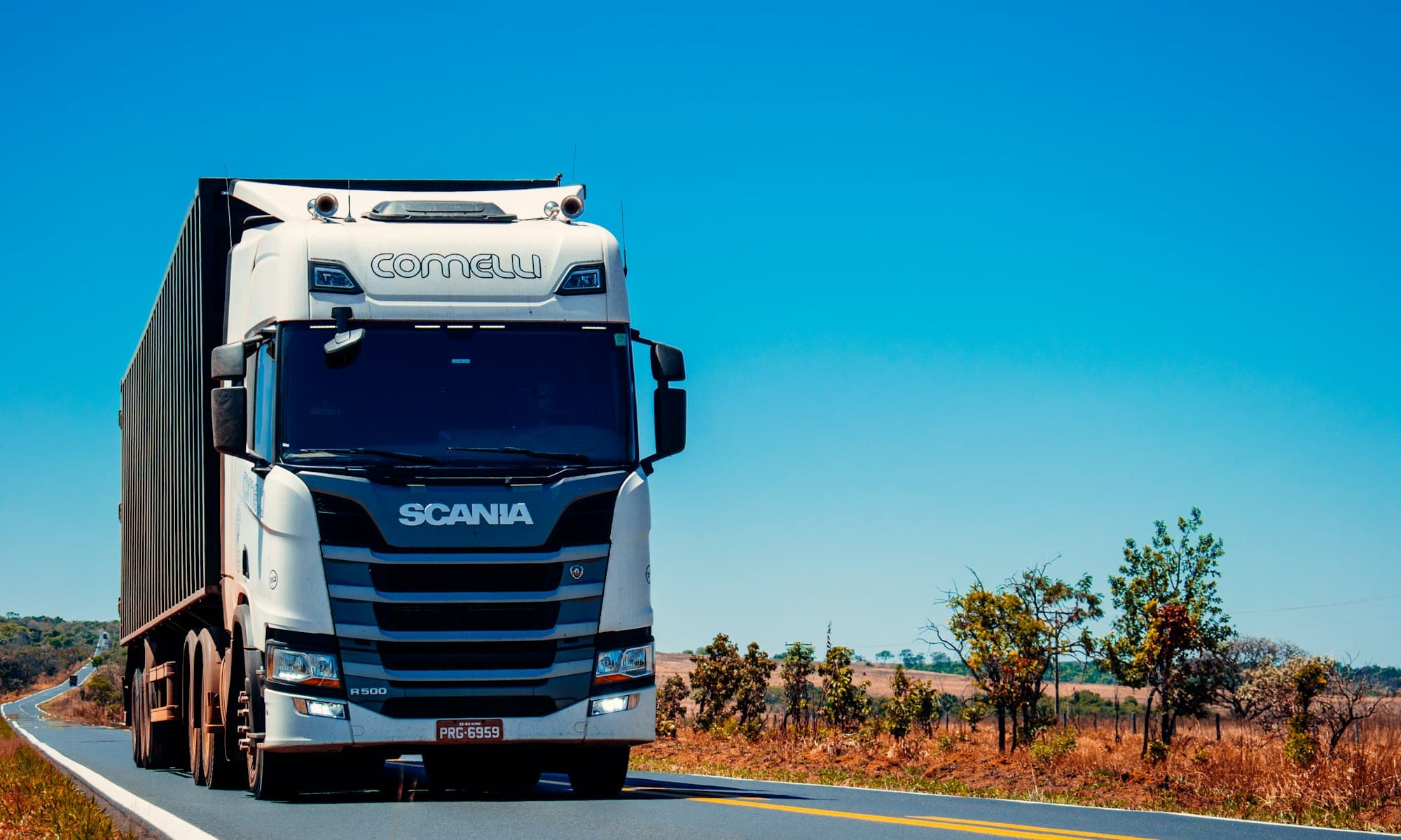 Blue semi-truck hauling a dry van trailer along an open American highway